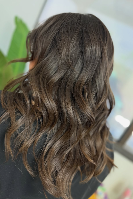 Voluminous loose waves with warm caramel-toned brunette color